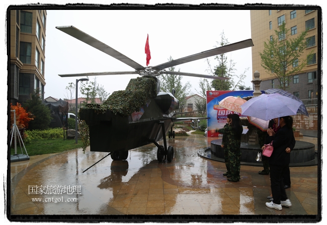 小區(qū)突然出現(xiàn)“飛機坦克”，其中殲15艦載戰(zhàn)斗機一架、99式主戰(zhàn)坦克一輛、武直-10武裝直升機一架，吸引了眾多市民雨中圍觀、合影。